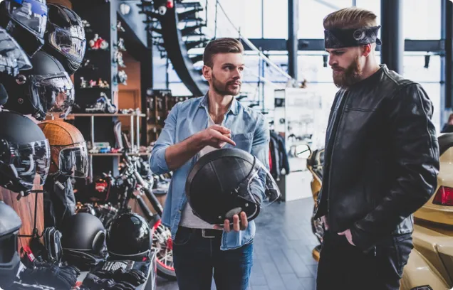 A salesperson showing a potential customer a motorcycle helmet